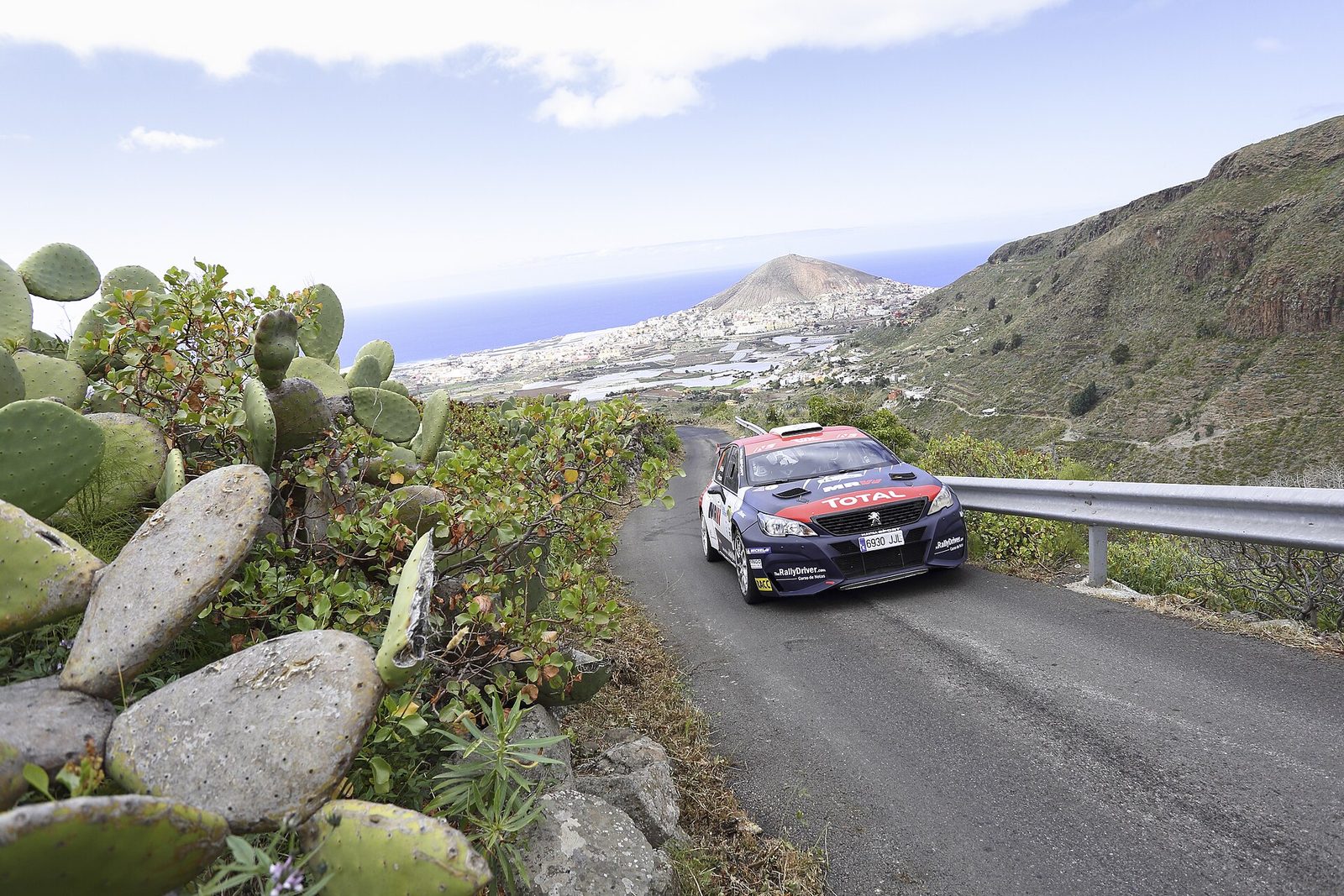 Peugeot 308 de rally en una carretera estrecha entre chumberas, con la costa al fondo, Rally Islas Canarias 2019
